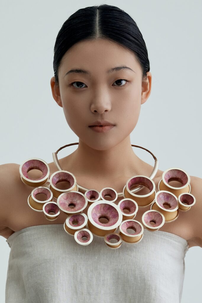 This piece continues to use my circular repetition design language to express recurring emotions in a reflective state. It is made with cherry blossom petals, calabash, and sterling silver.