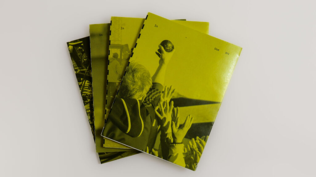 Four yellow-covered In-Use booklets arranged in a fan shape on a white background.