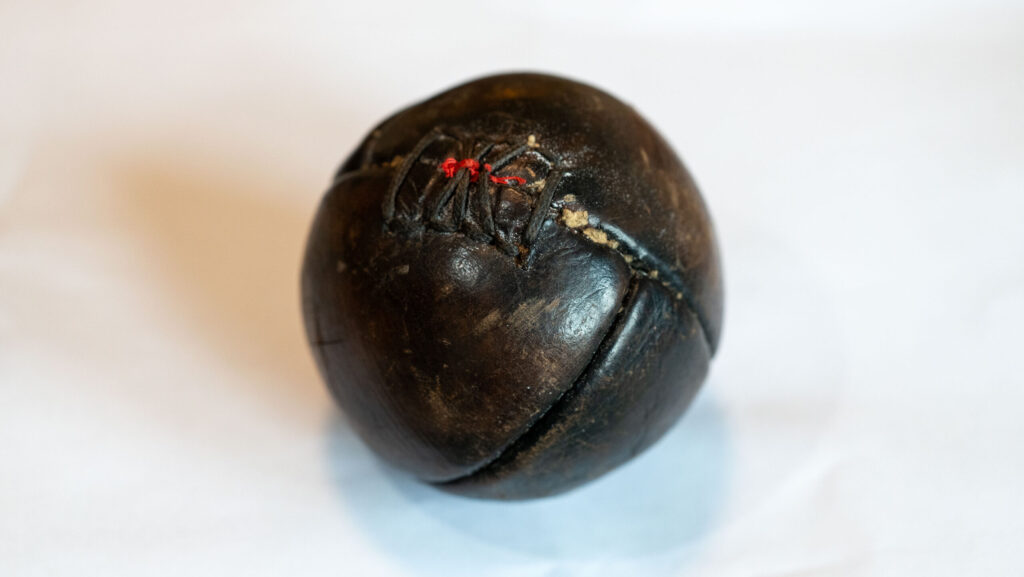 A close up image of a Hand Ball with visible repairs and stitching.