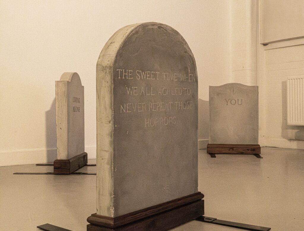 Three Gravestones standing in a warmly lit space